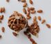 Bowl filled with raw almond nuts on white background