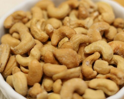 a white bowl filled with cashews on top of a table
